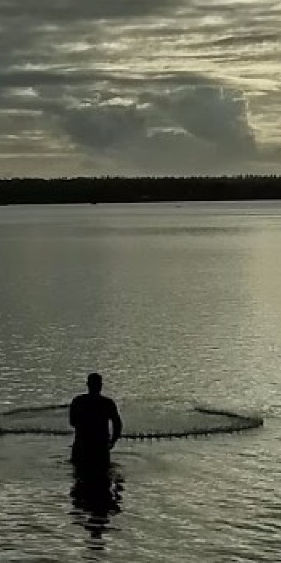 A man casting a fishing net.