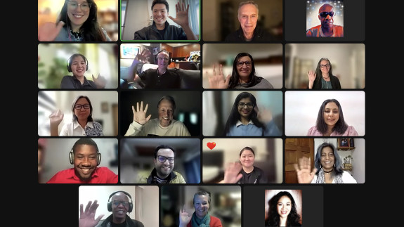 People wave during an online training