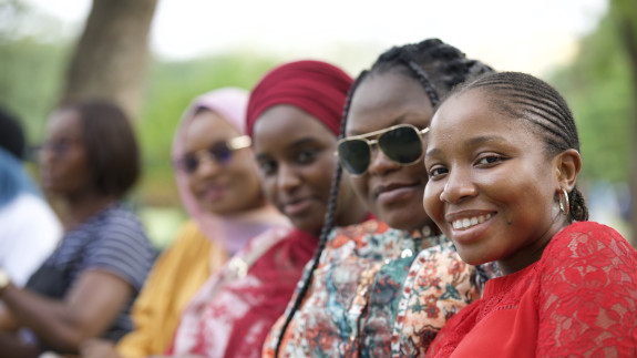 4 women in a row smiling at the camera