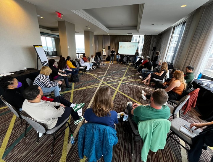 People sit in a circle during a presentation
