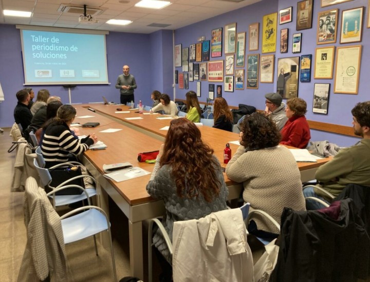People gather around a table for a solutions journalism workshop