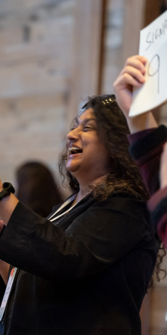 People hold up cards at an SJN Summit
