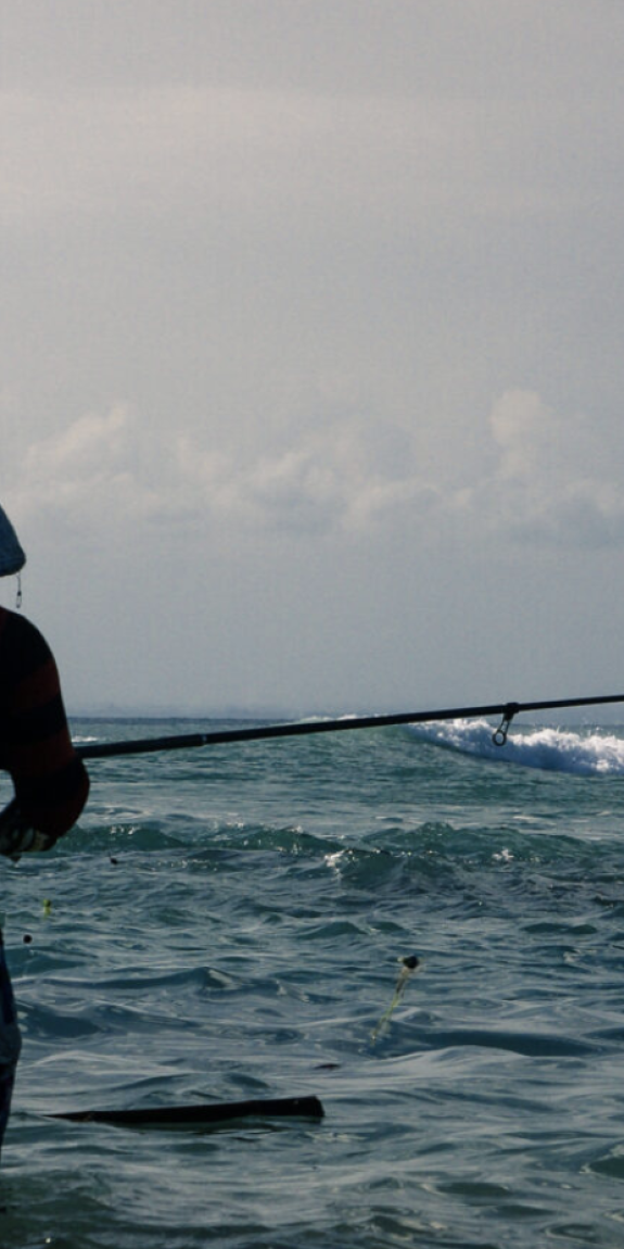 Two people fish in the ocean