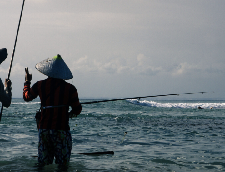 Two people fish in the ocean