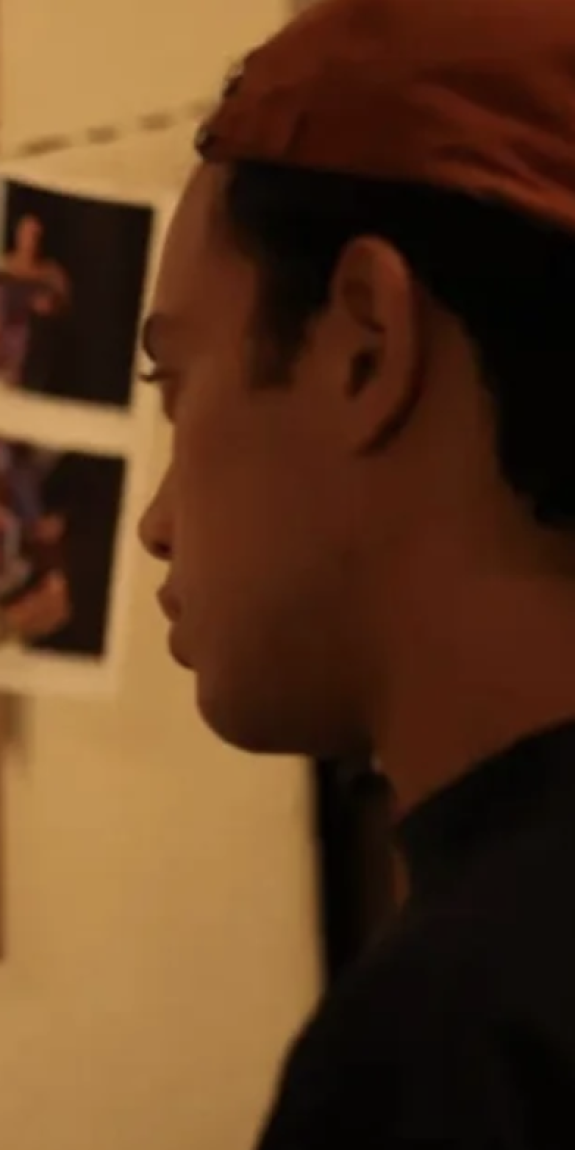 A journalist looks at story drafts and photos hung on a wall