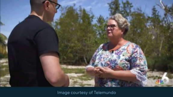 A journalist speaks with a community member outside
